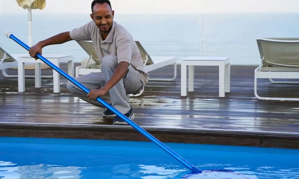 A man cleaning a swimming pool