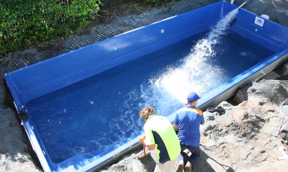 Two man installing swimming pool